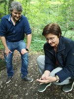 Rosi Steinberger und Tobias Lermer im Wald. Sie begutachten eine Gelbbauchunke in Rosi Steinbegers Hand.