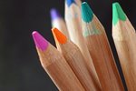 Symbolbild Bildung: bunte Holzbuntstifte in Großaufnahme vor dunklem Hintergrund