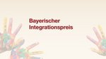 Beiger Hintergrund. In der Mitte der Schriftzug "Bayerischer Integrationspreis". Rechts und links unten ragen 3 ausgestreckte Hände in das Bild, die bunt bemalt sind.