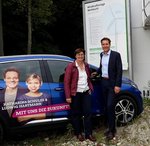 Die MdL Rosi Steinberger und Ludwig Hartmann vor dem Wahlkampfauto von Ludwig Hartmann, einem blauen Elektroauto