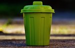 Symbolbild Müll: Das Bild zeigt eine klassische, runde, grüne Mülltonne mit Deckel.